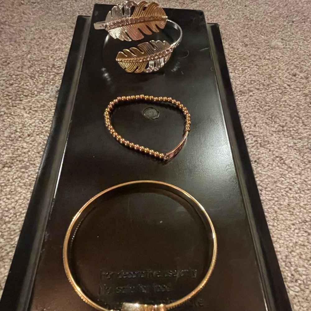 Three gold tone bracelets.